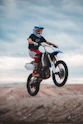 man in black and red motorcycle suit riding on red and white motocross dirt bike