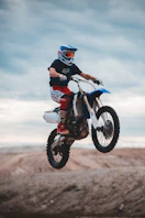 man in black and red motorcycle suit riding on red and white motocross dirt bike