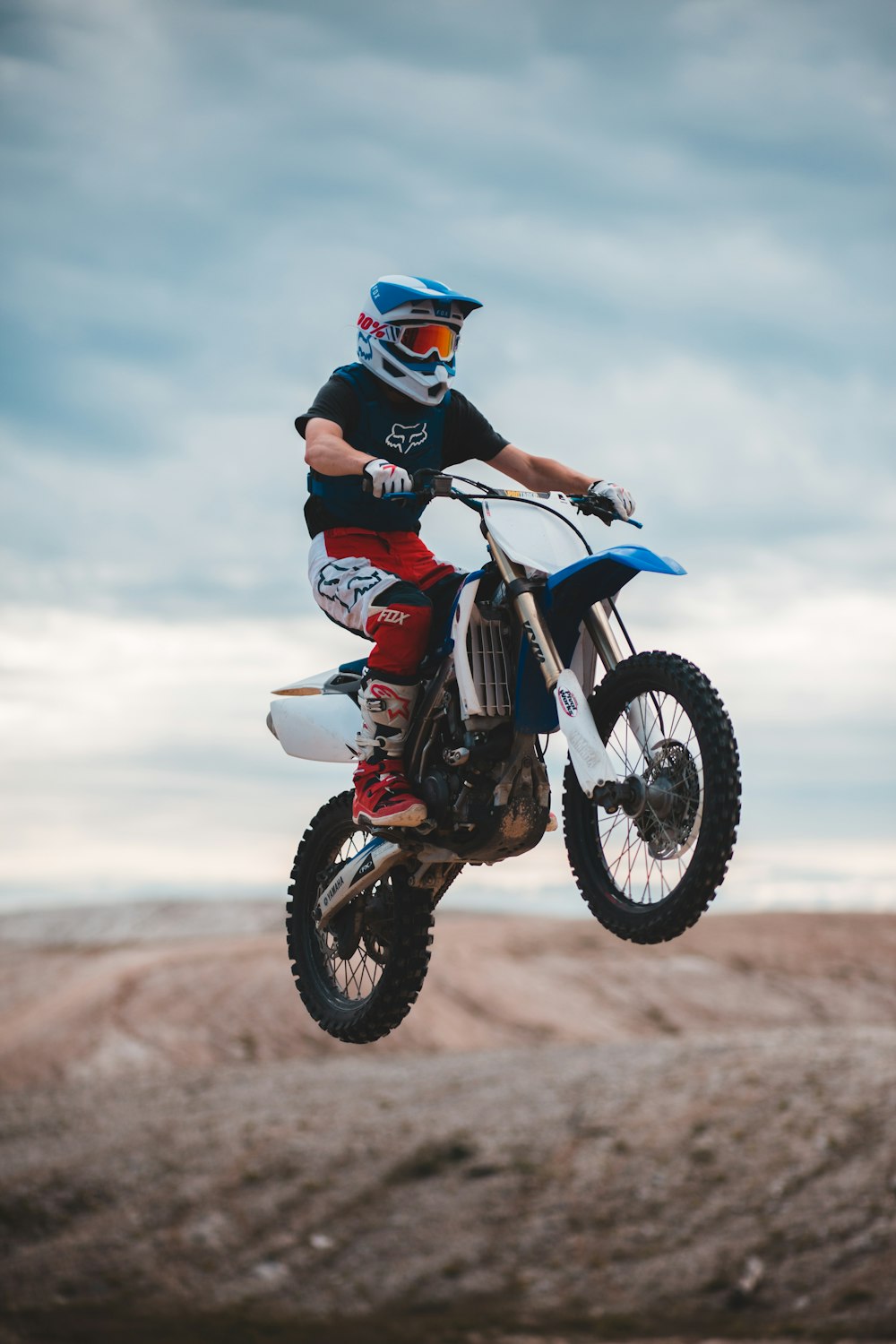 man in black and red motorcycle suit riding on red and white motocross dirt bike