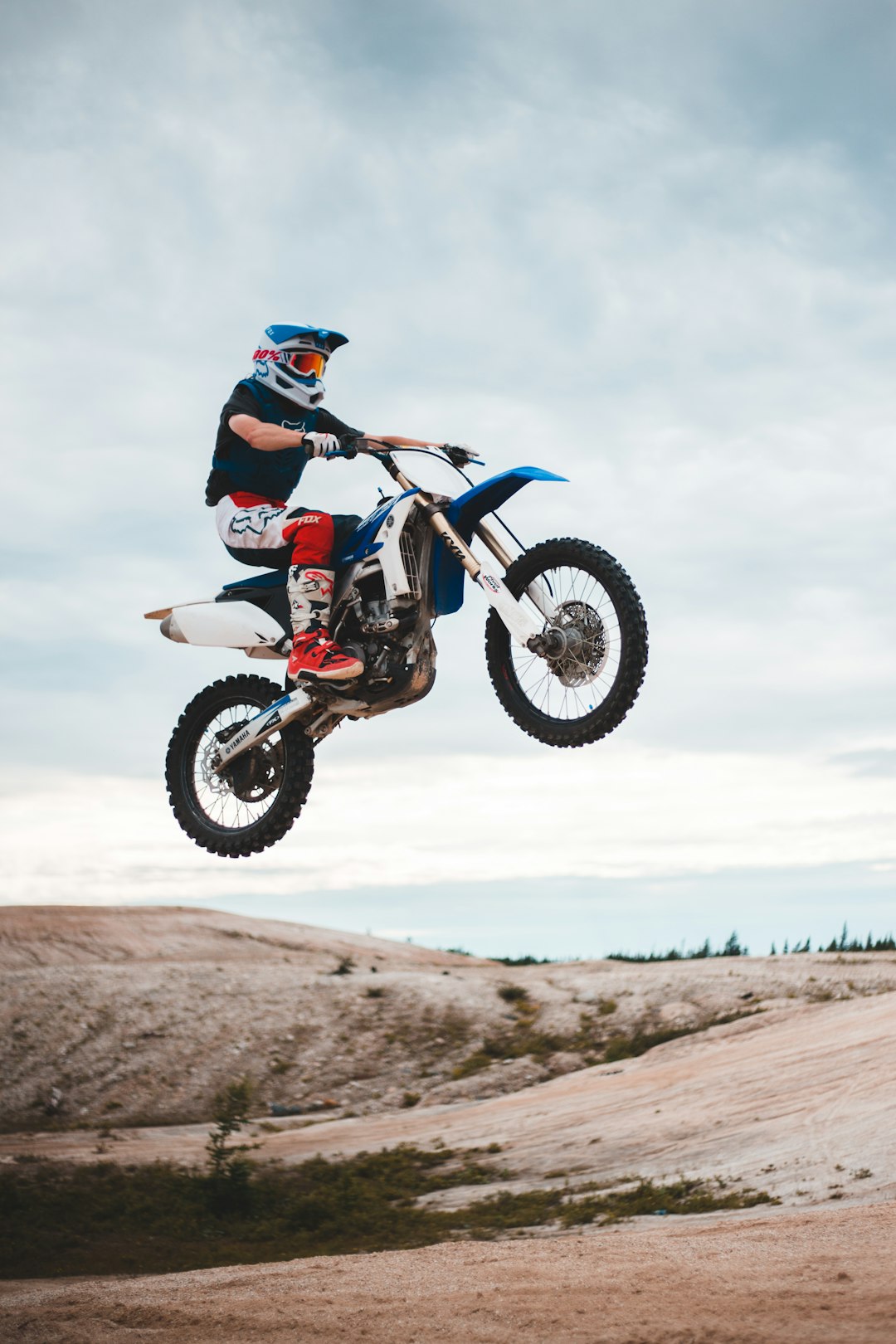 man riding blue and white motocross dirt bike