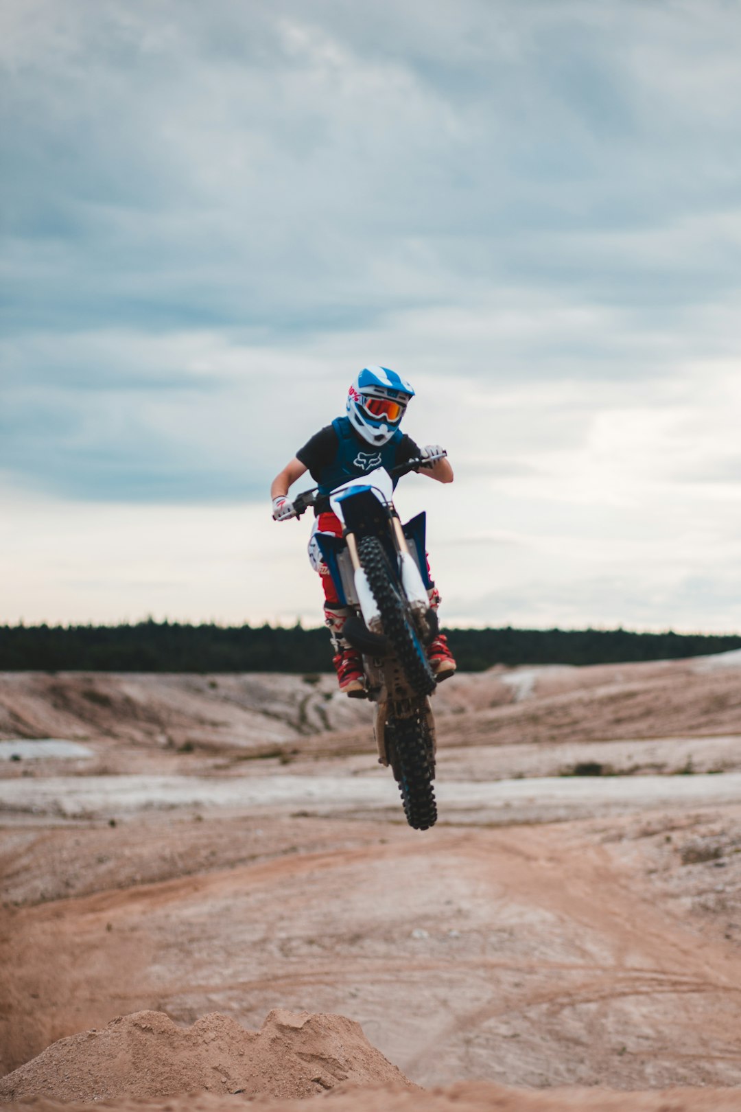 man in blue and white motocross helmet riding motocross dirt bike