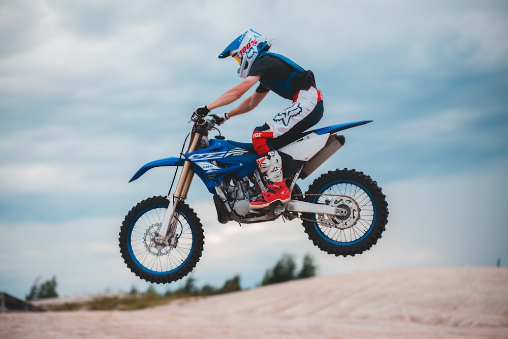 Foto Hombre en traje de motocross azul y rojo montando motocross dirt bike  – Imagen Motocicleta gratis en Unsplash