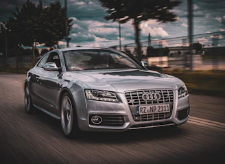 A sleek Audi with a turbo upgrade racing on a winding track under a clear blue sky.