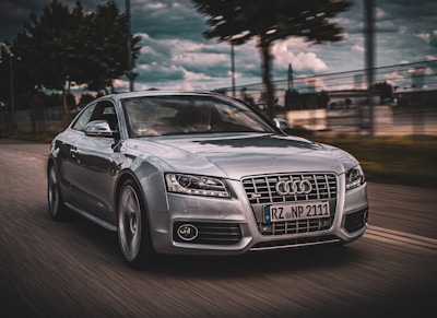 Dynamic shot of a BMW M3 speeding on a winding road under a dramatic sky.