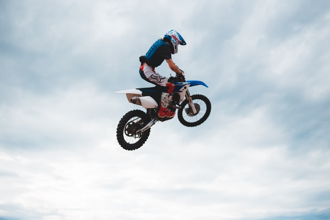 man in blue jacket riding motocross dirt bike