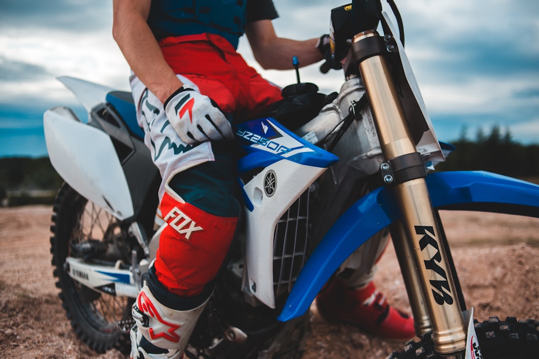 man in red and white motocross helmet riding blue and white motocross dirt bike