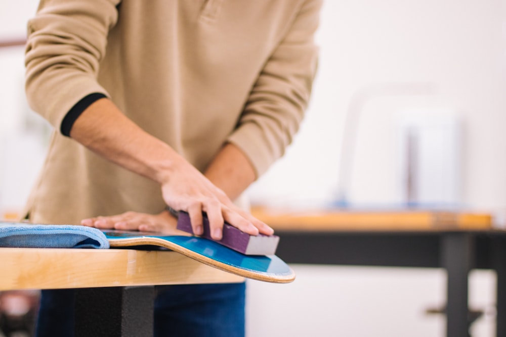 person in brown long sleeve shirt holding blue book