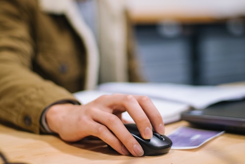 person holding computer mouse in process of continuous learning