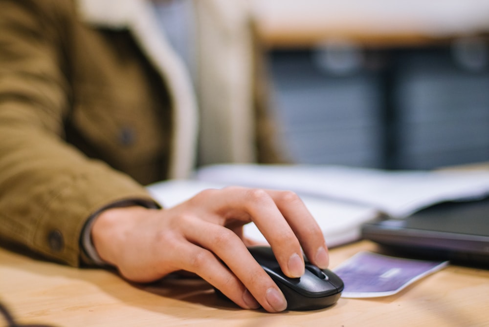 person holding black cordless computer mouse