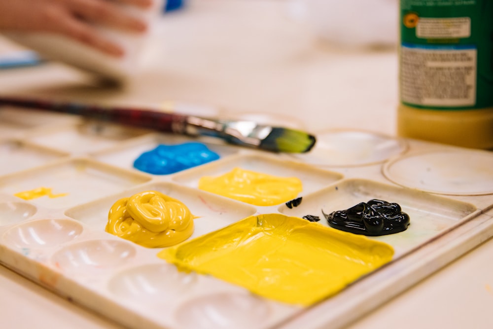 a close up of a paint tray with paint and a brush