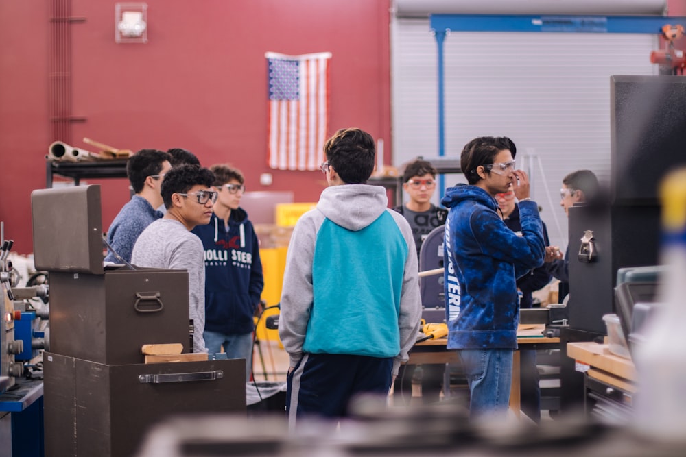 personas de pie frente a una computadora portátil