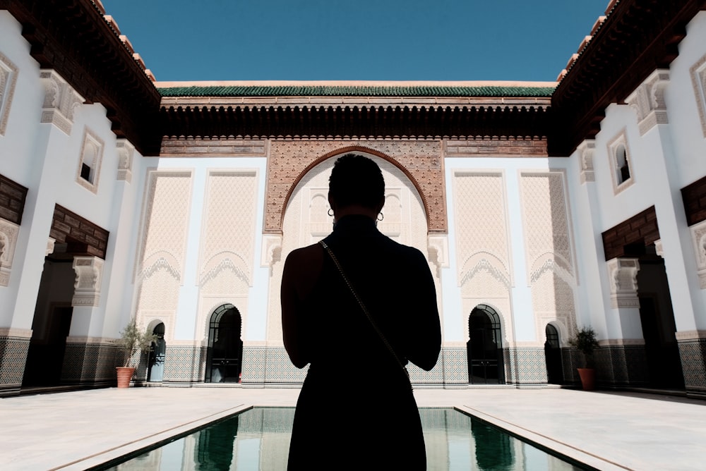 Homme en manteau noir debout près d'un bâtiment en béton blanc pendant la  journée photo – Photo Maroc Gratuite sur Unsplash