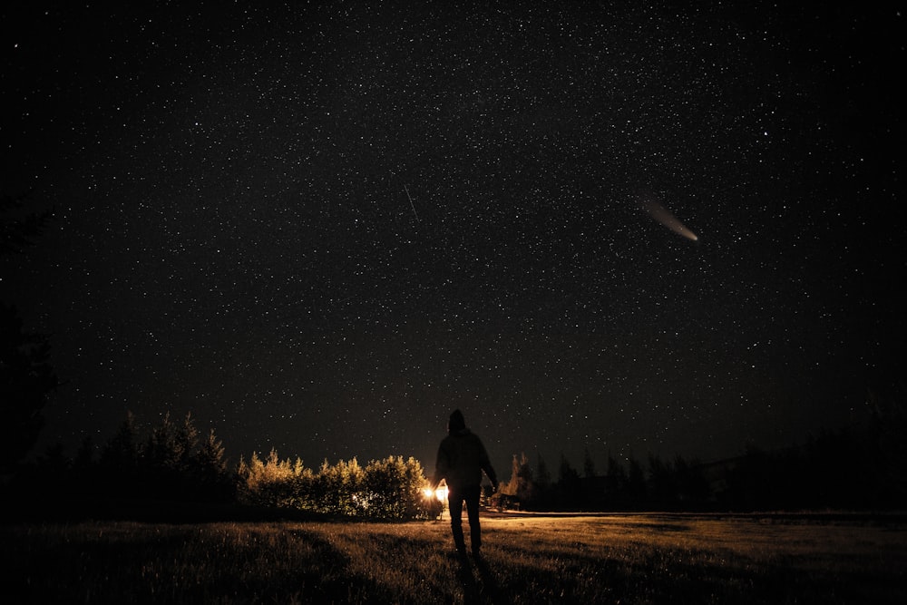 man and woman walking on dirt road during night time