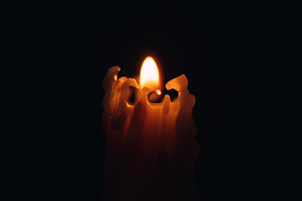 lighted candle in dark room