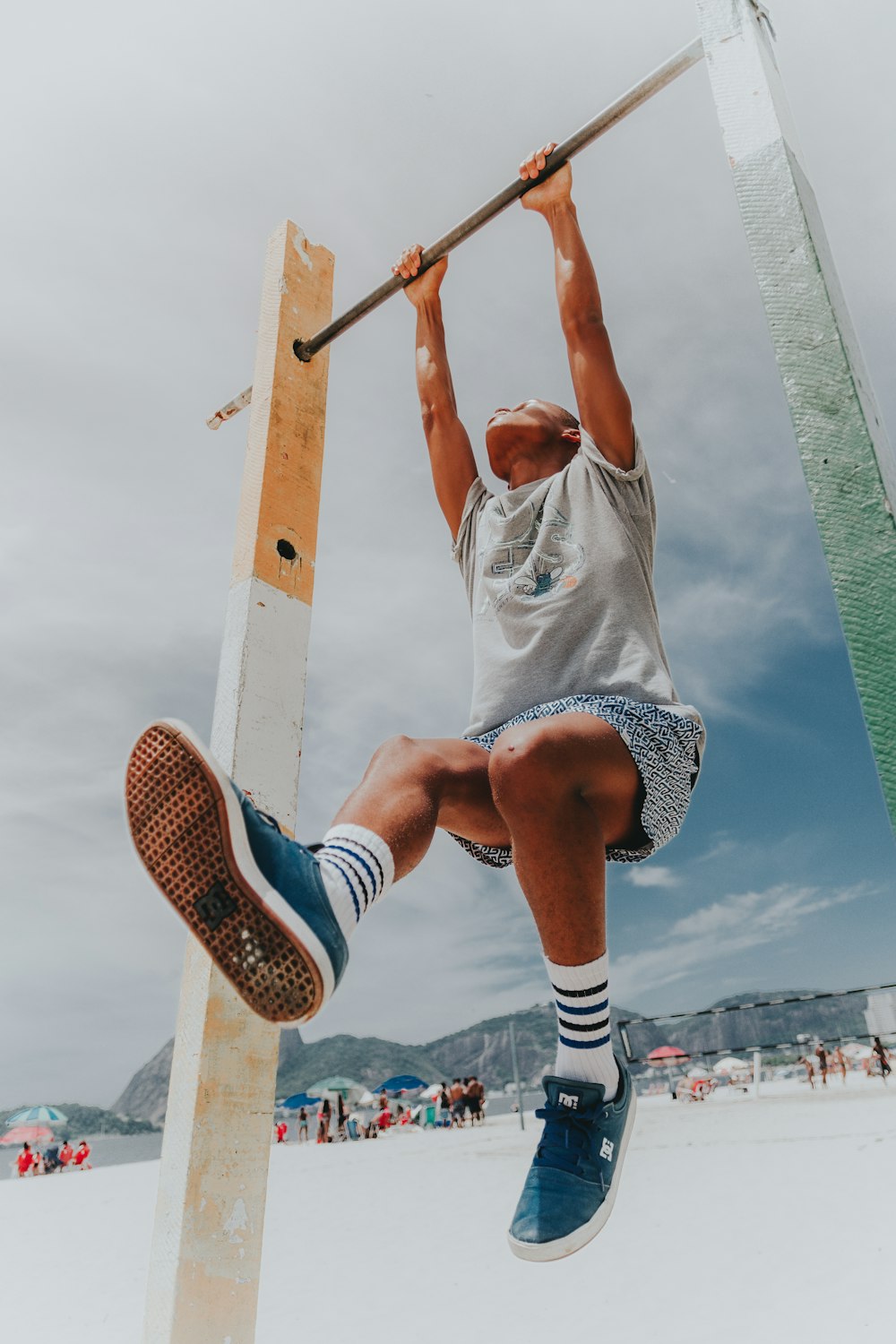 man in white crew neck t-shirt and black and white striped shorts sitting on brown