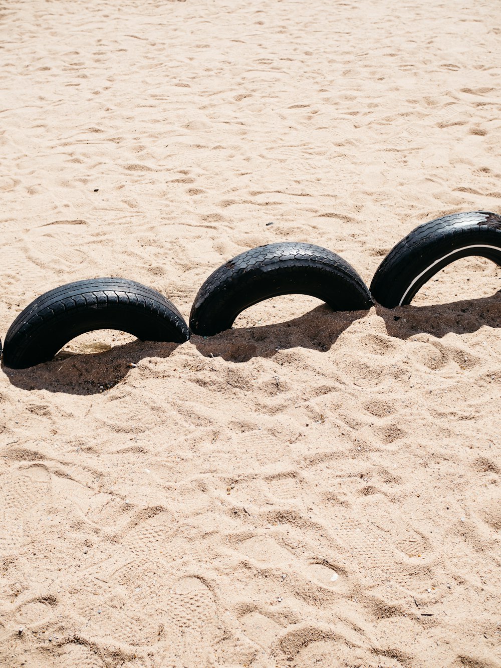 black car tire on brown sand