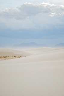 white sand under white clouds during daytime