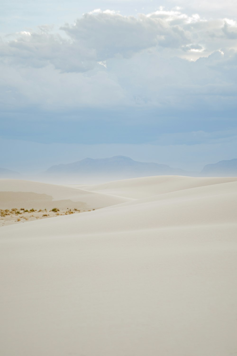 white sand under white clouds during daytime