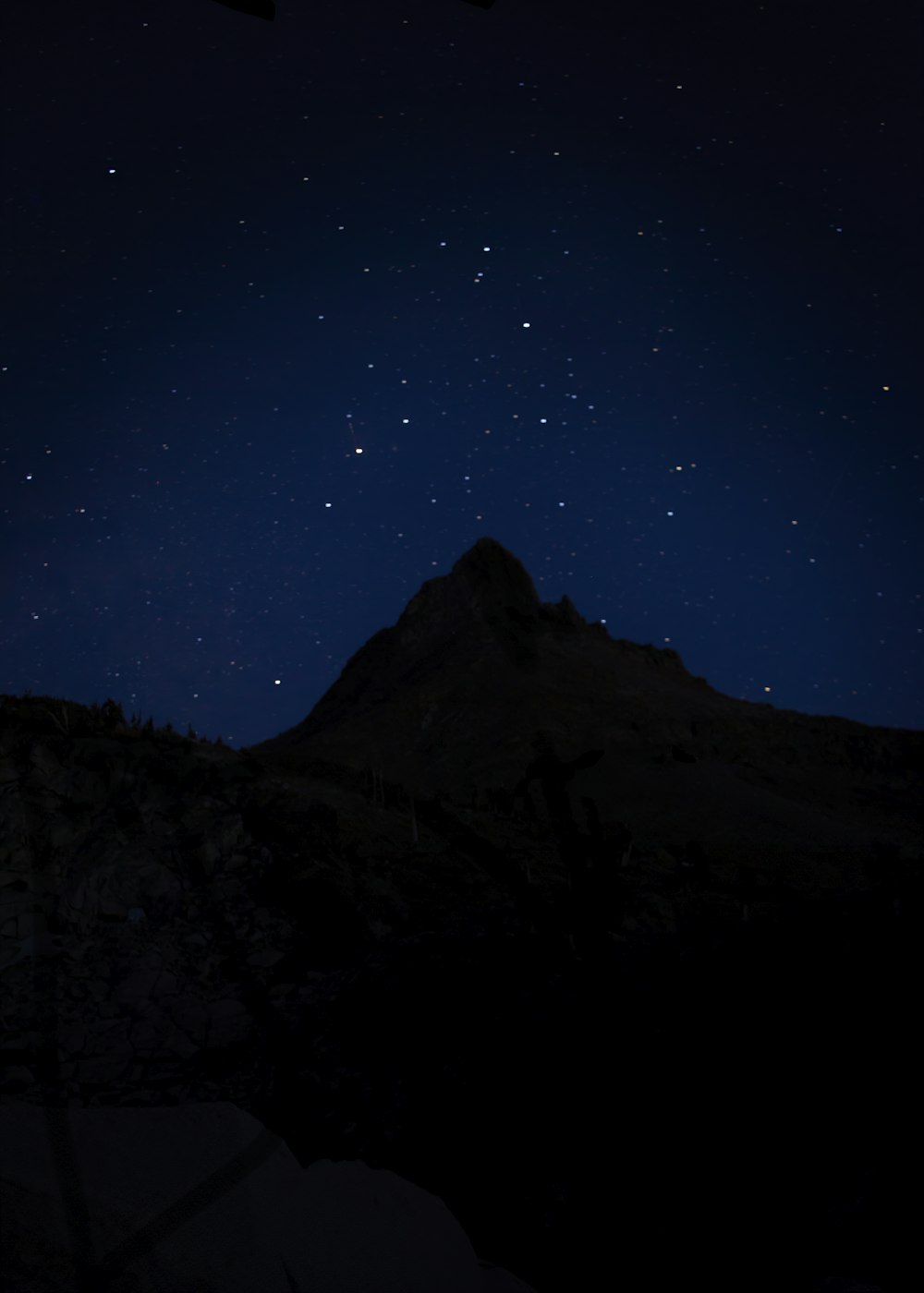 silhouette of mountain under blue sky during night time