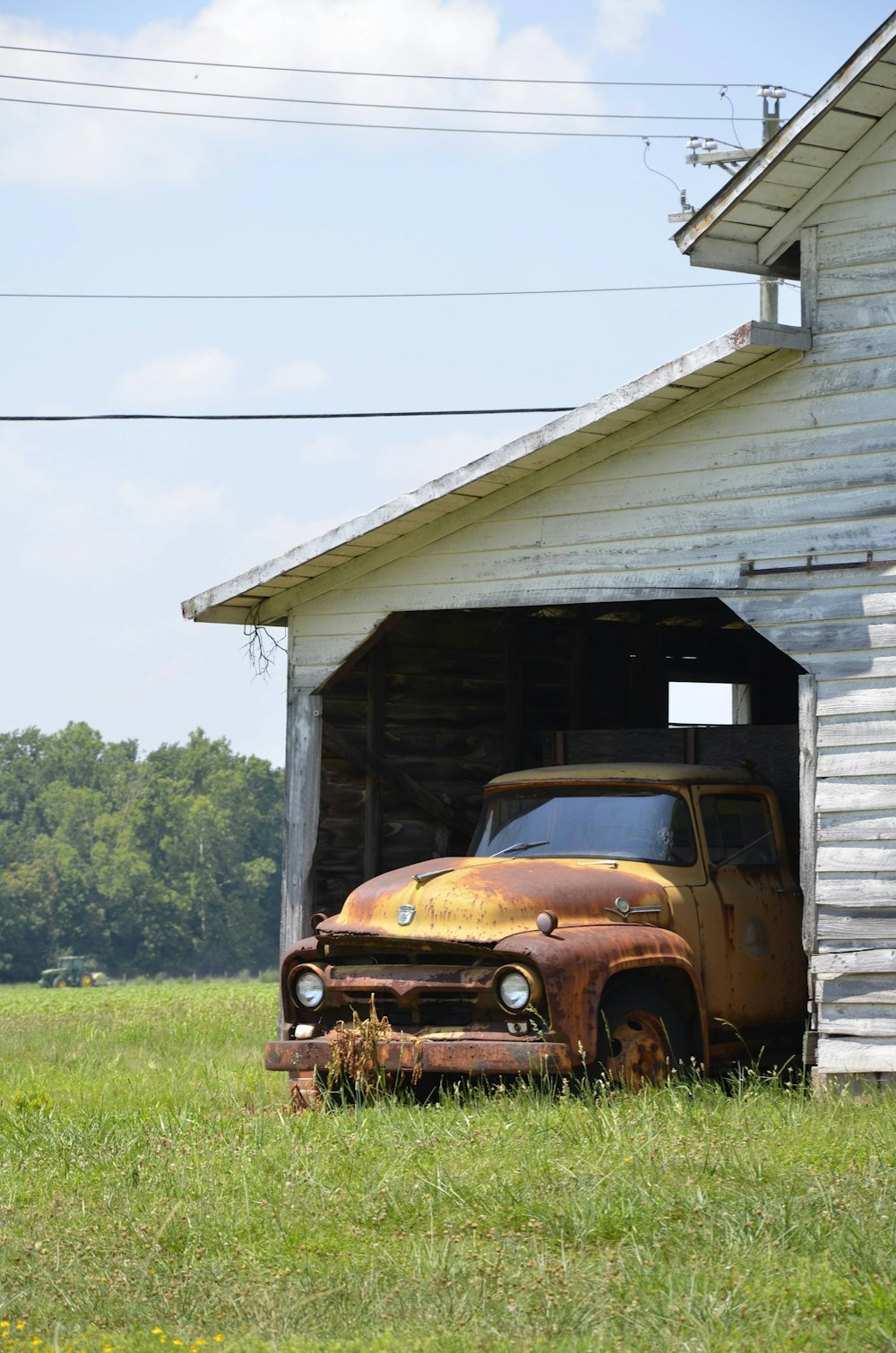 brown car parked beside brown wooden house during daytime