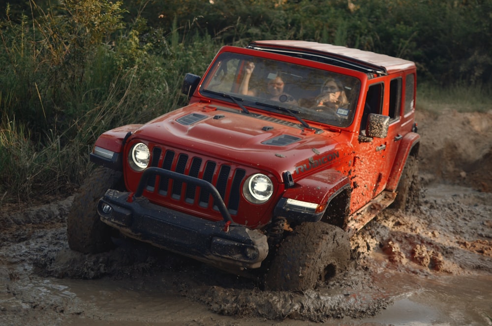 Jeep Wrangler rouge sur un chemin de terre