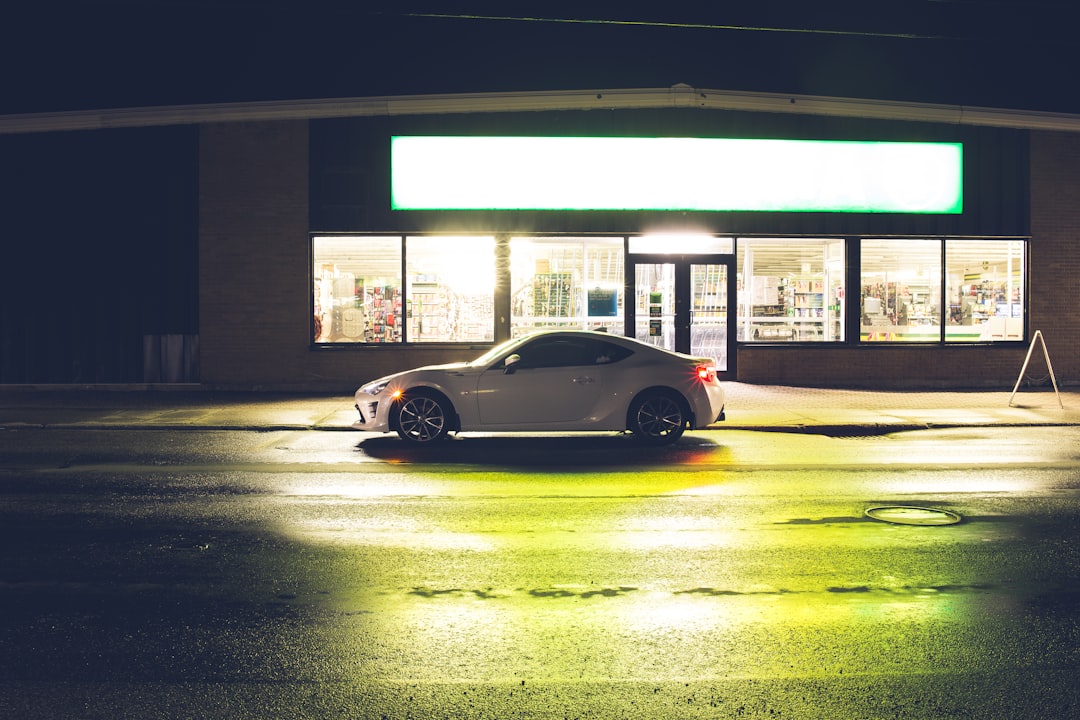 yellow porsche 911 parked in front of white building