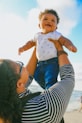 woman in black and white striped long sleeve shirt carrying baby in blue onesie