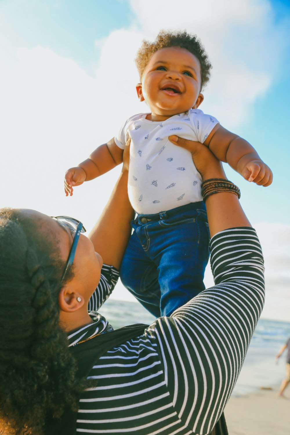 Frau in schwarz-weiß gestreiftem Langarmshirt mit Baby in blauem Onesie