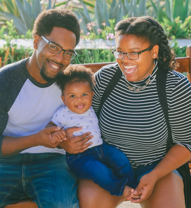 woman in black and white striped shirt carrying baby in blue onesie