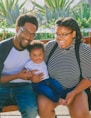 woman in black and white striped shirt carrying baby in blue onesie