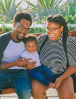 woman in black and white striped shirt carrying baby in blue onesie