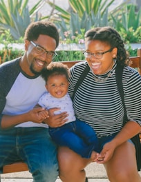 woman in black and white striped shirt carrying baby in blue onesie