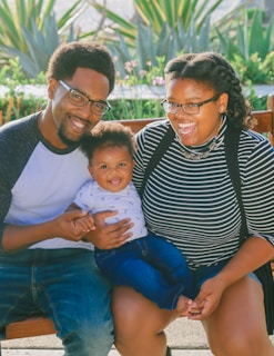 woman in black and white striped shirt carrying baby in blue onesie