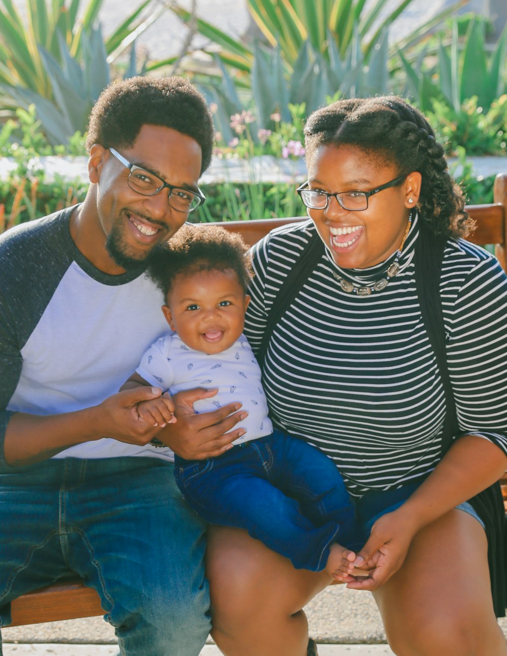 woman in black and white striped shirt carrying baby in blue onesie