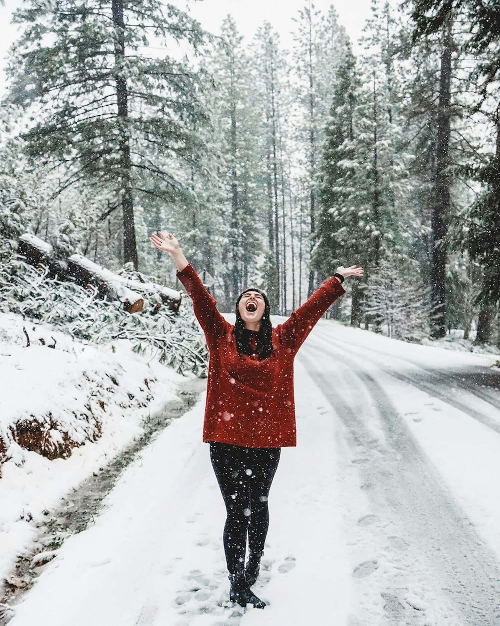 Mujer con chaqueta rosa de pie en el suelo cubierto de nieve