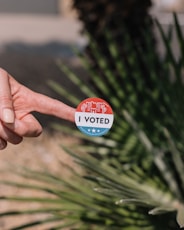 person holding red and white round pin