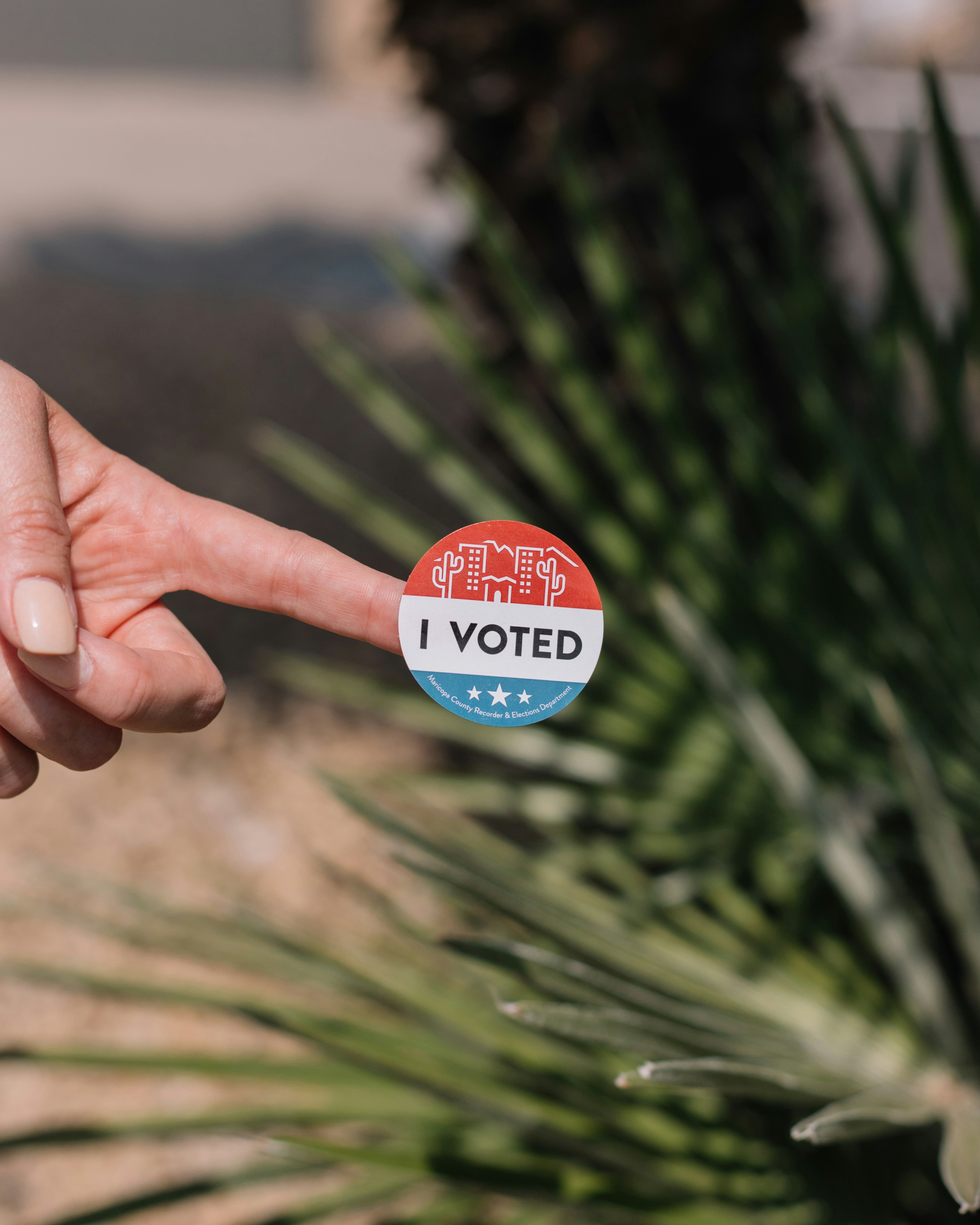 Arizona desert themed I voted voting sticker with palm tree and desert landscaping in background.