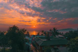 A vibrant sunset over a coastal town, with influencers capturing the moment on camera.