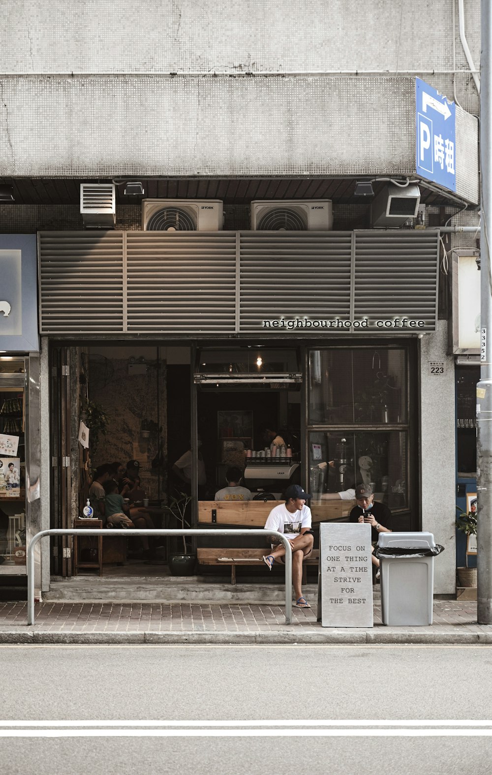 people sitting on bench in front of store during daytime