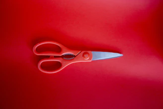 red handled scissors on red textile