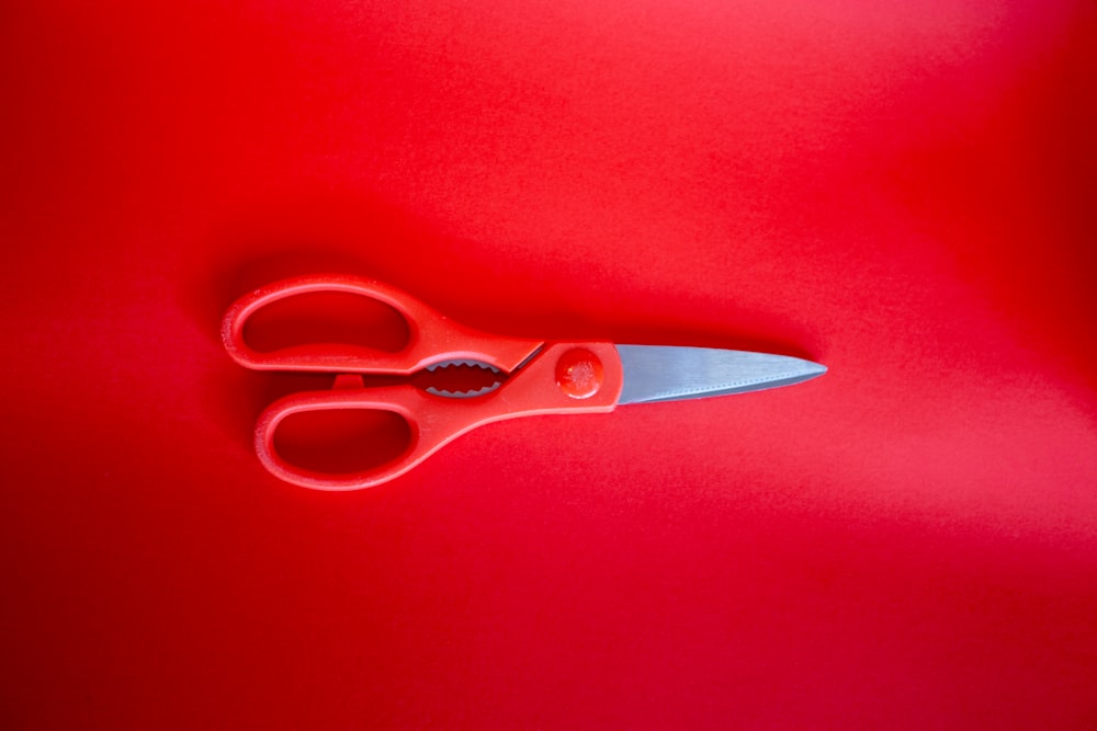 red handled scissors on red textile