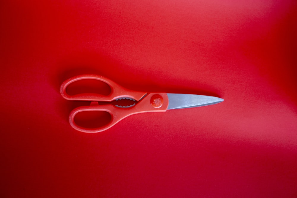 red handled scissors on red textile