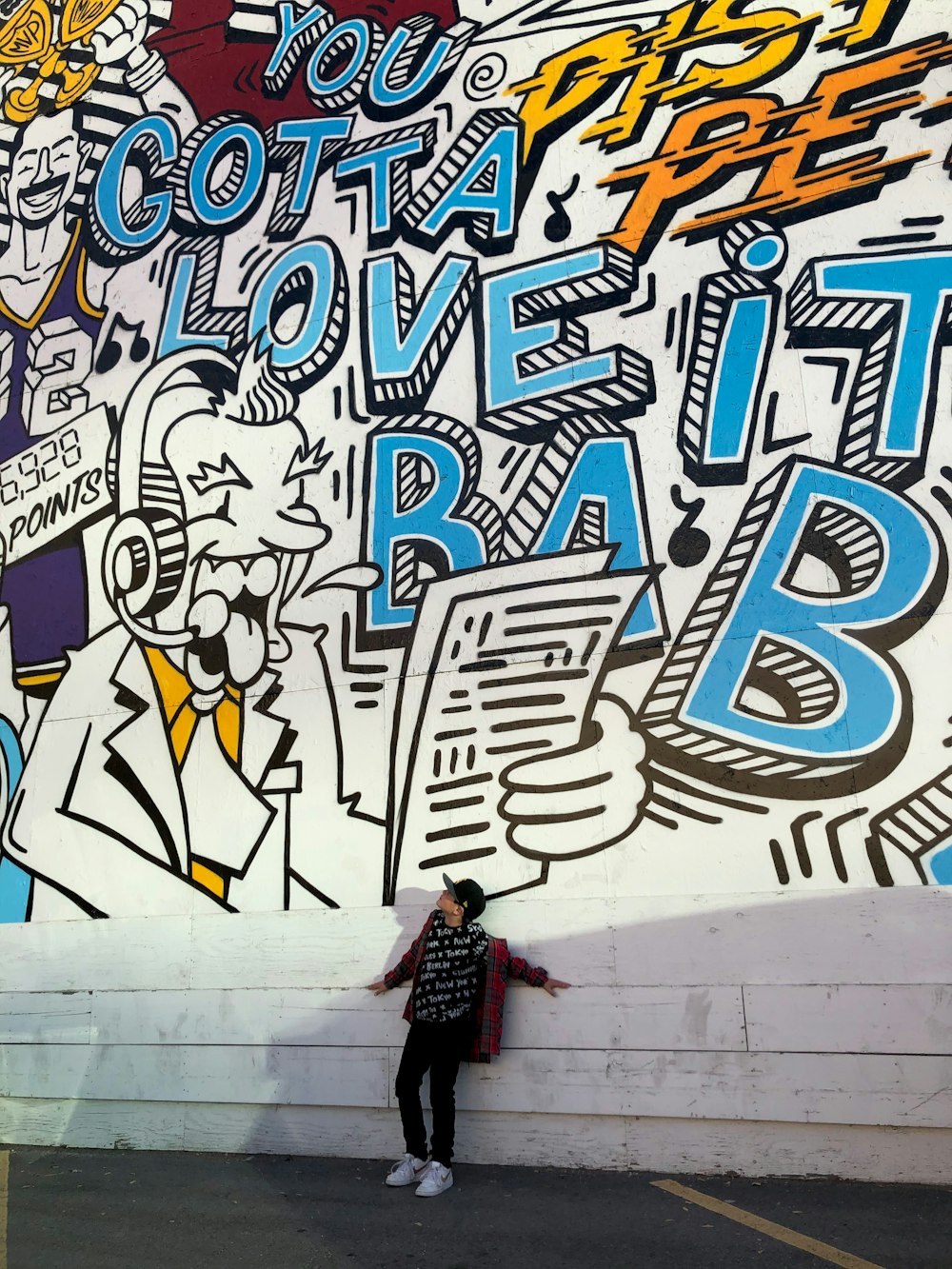 woman in black jacket and black pants standing beside wall with graffiti