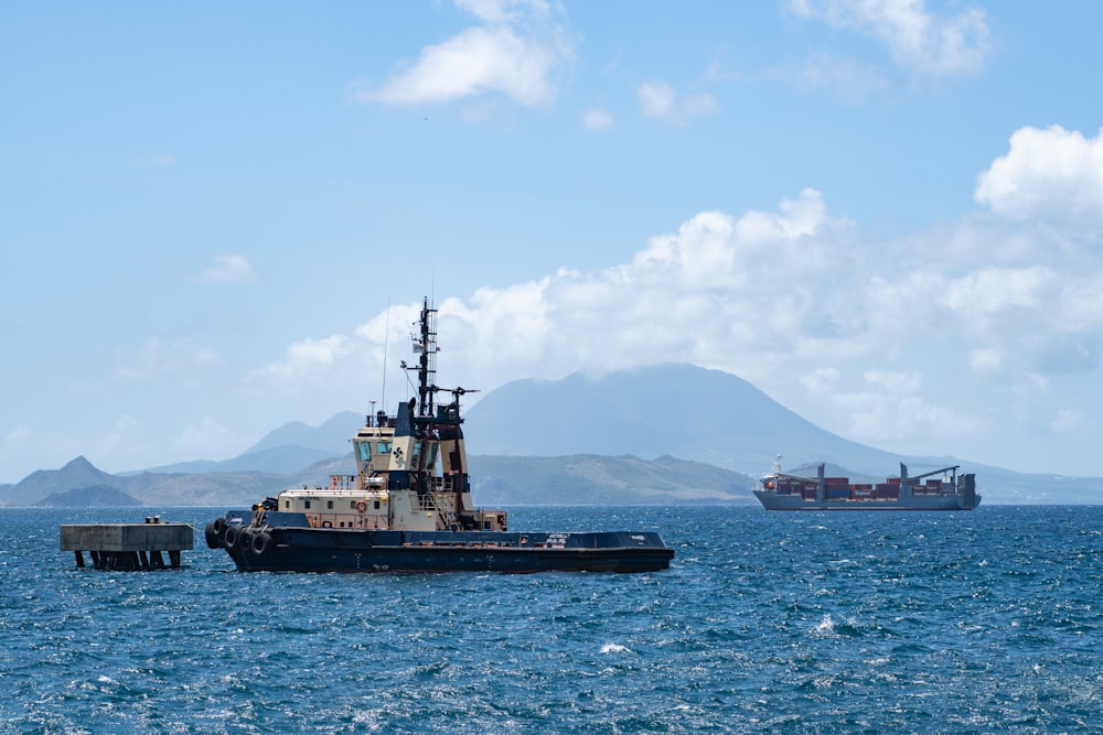 black ship on sea under white clouds during daytime