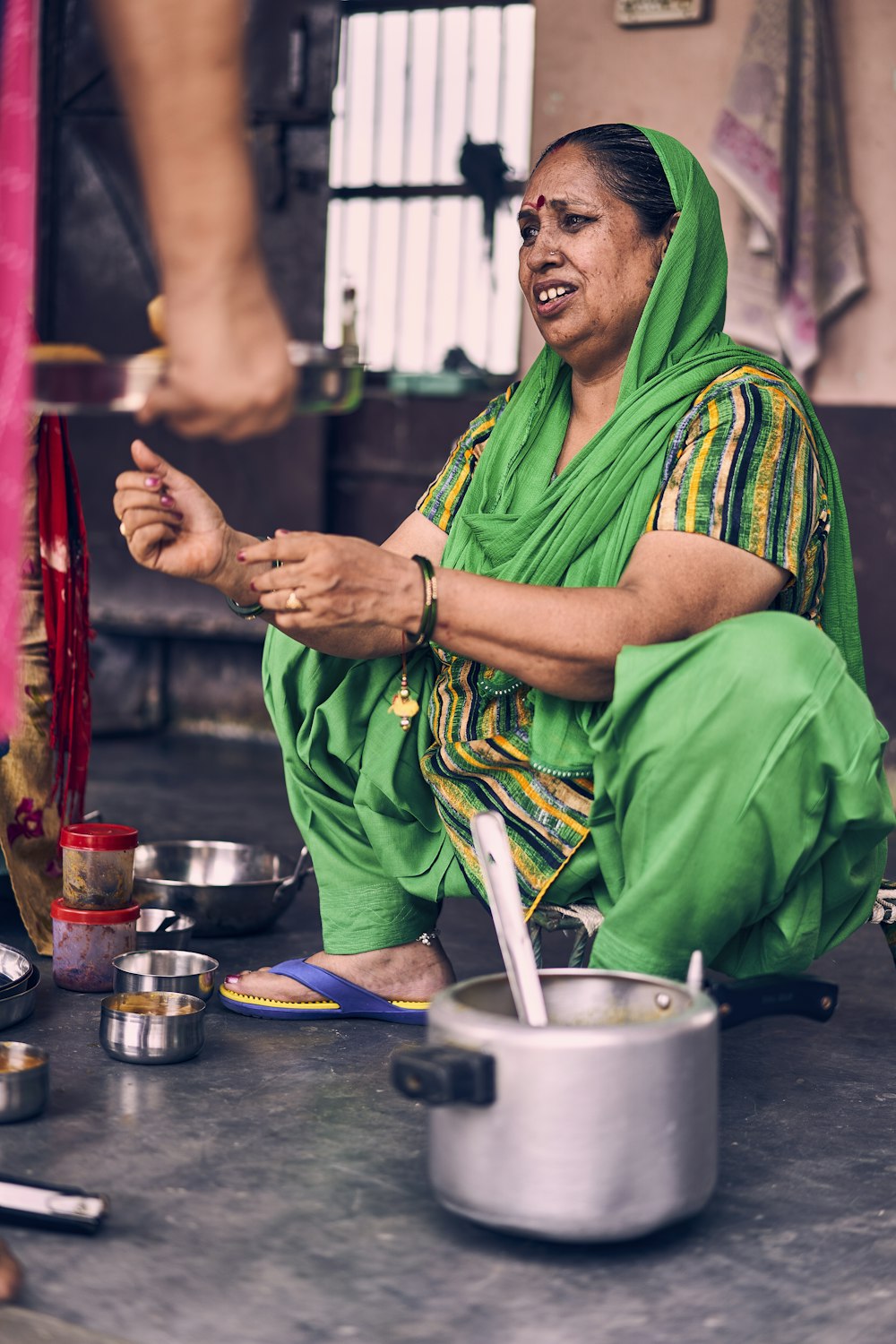 man in green and yellow traditional dress sitting on blue table