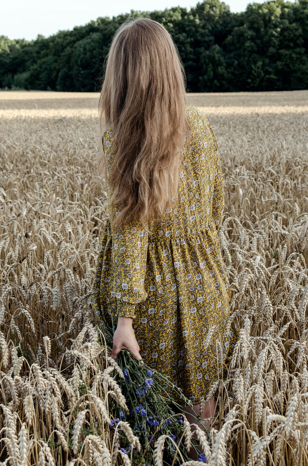 woman in yellow and black dress standing on brown grass field during daytime