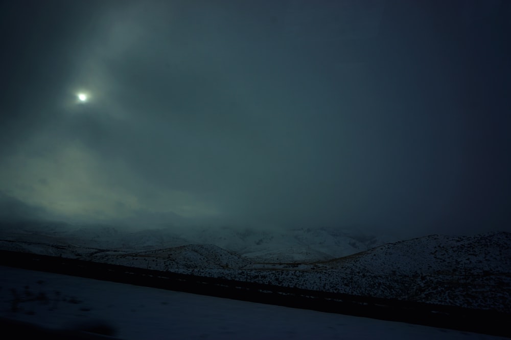 snow covered mountain under cloudy sky during night time