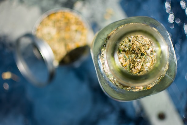 Clear plastic jar with black lid filled with light brown herbal powder, labeled with Rahma Wellness branding, set against a soft beige background.