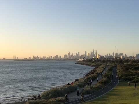 A panoramic view of a bustling Gulf city skyline at sunset, highlighting modern infrastructure.