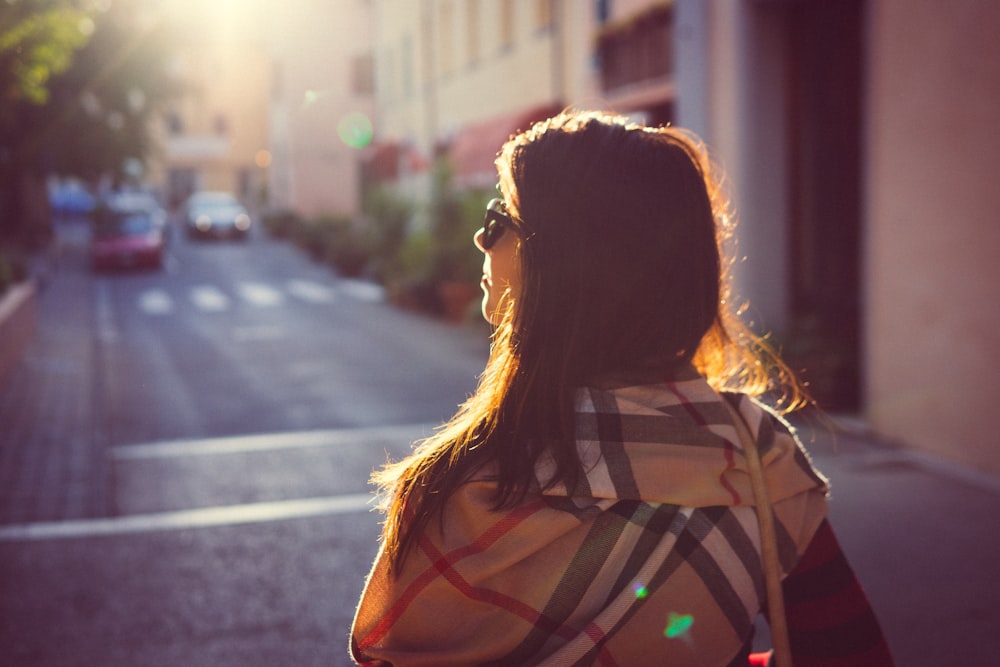 woman in black and white stripe shirt standing on sidewalk during daytime